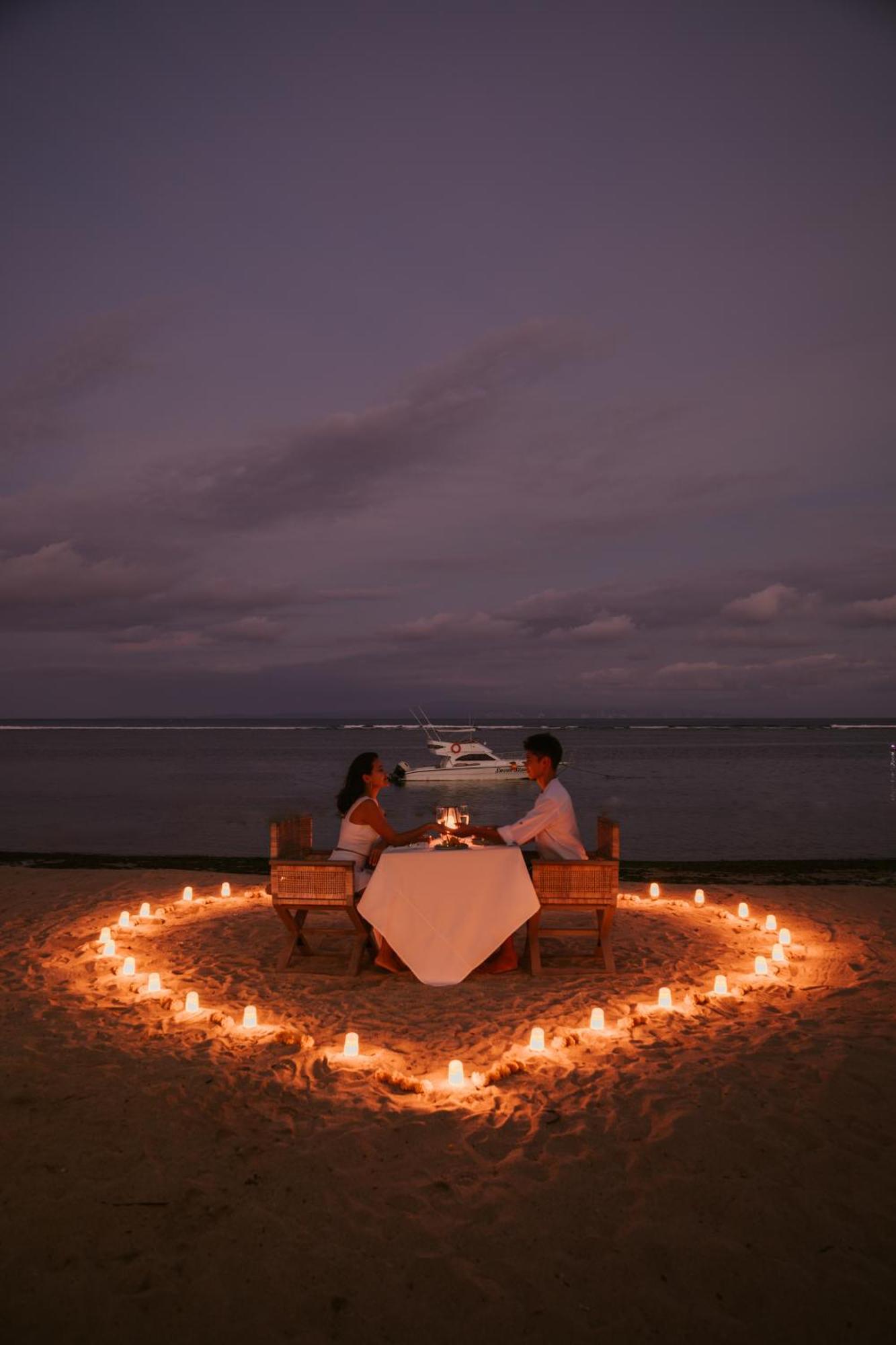 נוסא דואה Sadara Resort מראה חיצוני תמונה A couple dining on a beach at night