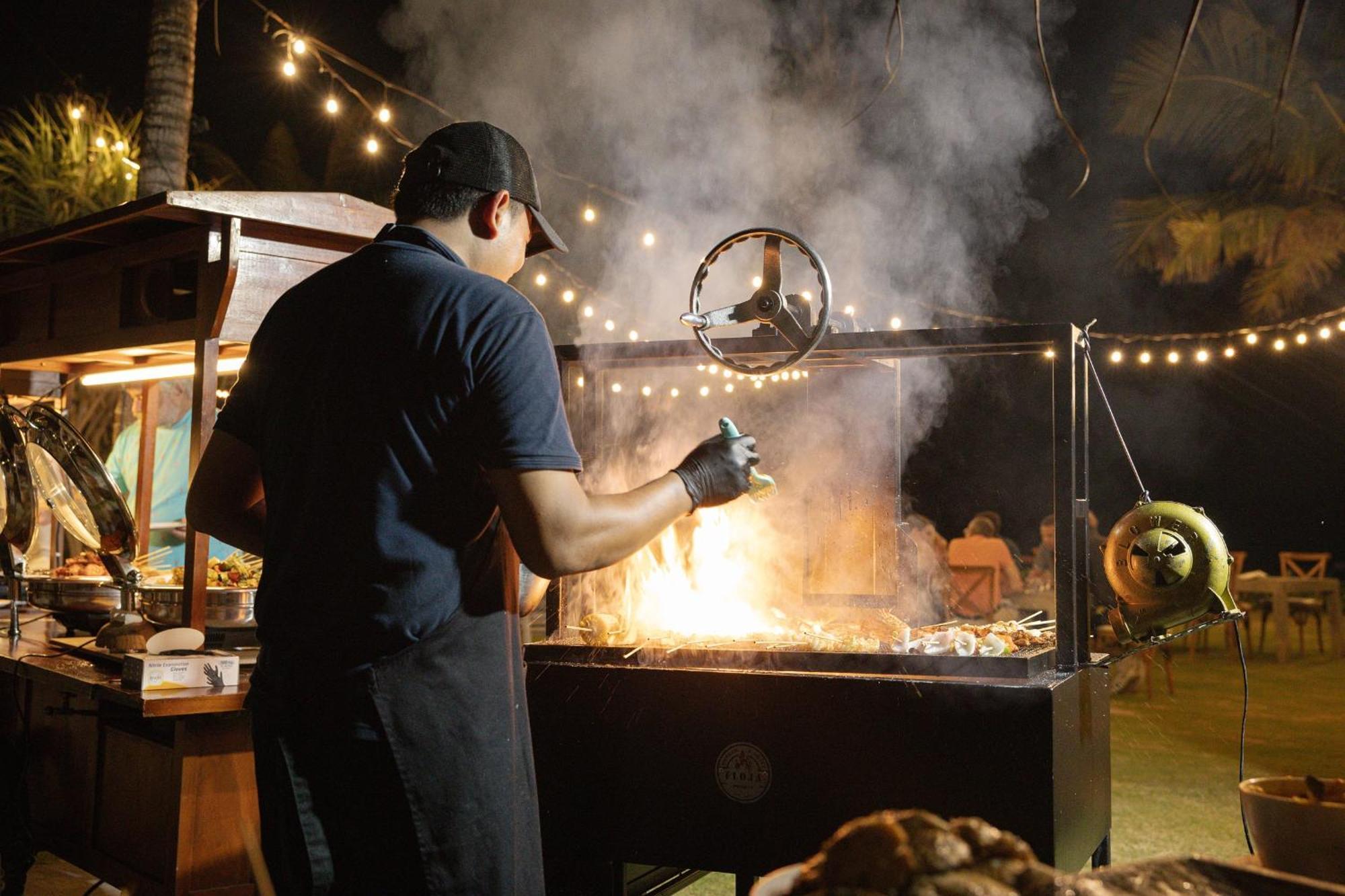 נוסא דואה Sadara Resort מראה חיצוני תמונה A chef cooking over a wood-burning grill
